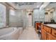Bright bathroom featuring a soaking tub, frameless shower, and granite countertops at 3895 Mimosa Pl, Palm Harbor, FL 34685