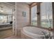 Corner soaking tub and bedroom view through the door of the en-suite bathroom at 3895 Mimosa Pl, Palm Harbor, FL 34685
