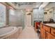 Bright bathroom featuring a soaking tub, frameless shower, and granite countertops at 3895 Mimosa Pl, Palm Harbor, FL 34685
