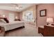 Comfortable bedroom boasts a large window seat, soft carpet, ceiling fan and relaxing decor at 3895 Mimosa Pl, Palm Harbor, FL 34685