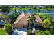 Stunning waterfront home featuring a tile roof, two-car garage, lush landscaping, and palm trees at 3895 Mimosa Pl, Palm Harbor, FL 34685