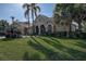 Attractive home with lush landscaping, mature palm trees, and a two-car garage, offering curb appeal at 3895 Mimosa Pl, Palm Harbor, FL 34685