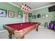 Spacious game room with a classic pool table, unique lighting, and wall decor creating an inviting entertainment space at 3895 Mimosa Pl, Palm Harbor, FL 34685