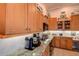 Bright kitchen featuring granite countertops, wood cabinets, and modern appliances at 3895 Mimosa Pl, Palm Harbor, FL 34685