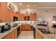 Spacious kitchen with granite counters, stainless sink, wood cabinets, and modern lighting at 3895 Mimosa Pl, Palm Harbor, FL 34685