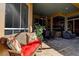 Relaxing patio area with comfortable wicker furniture, brick flooring, and views of the lush outdoor space at 3895 Mimosa Pl, Palm Harbor, FL 34685