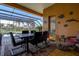 Covered patio featuring a dining set, seating, and a screened enclosure offering views of the pool and landscape at 3895 Mimosa Pl, Palm Harbor, FL 34685