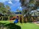 Colorful playground with swings, slides, and climbing structures set on a grassy area at 3895 Mimosa Pl, Palm Harbor, FL 34685