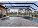 Screened-in pool area boasting a spa, water feature, and views of the lake and surrounding landscape for outdoor enjoyment at 3895 Mimosa Pl, Palm Harbor, FL 34685