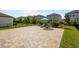 Paver patio with lounge chairs and lush landscaping; perfect for outdoor entertaining and relaxation at 4077 Cadence Loop, Land O Lakes, FL 34638