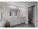 Clean, modern bathroom features dual sinks, bright lighting, and wood look tile at 4077 Cadence Loop, Land O Lakes, FL 34638