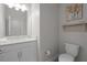Clean bathroom features a white vanity, a toilet, and art decor on the light gray wall at 4077 Cadence Loop, Land O Lakes, FL 34638