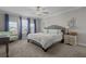 Bright bedroom with plush carpeting, a comfortable queen-sized bed, and lots of natural light from large windows at 4077 Cadence Loop, Land O Lakes, FL 34638