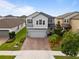 Charming two-story home features a brick driveway and manicured landscaping at 4077 Cadence Loop, Land O Lakes, FL 34638