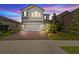 Charming two-story home with landscaped yard, brick driveway, two-car garage, and neutral gray paint at 4077 Cadence Loop, Land O Lakes, FL 34638