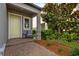 Charming front porch with brick accents, a cozy seating area, and well-manicured landscaping at 4077 Cadence Loop, Land O Lakes, FL 34638