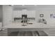 Modern kitchen is complete with white cabinets, quartz countertops, stainless steel appliances, and a breakfast bar at 4077 Cadence Loop, Land O Lakes, FL 34638