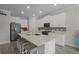 Modern kitchen with white cabinets, stainless steel appliances, grey backsplash, and island with seating at 4077 Cadence Loop, Land O Lakes, FL 34638