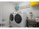 Organized laundry room with washer, dryer, wire shelving, and decor at 4077 Cadence Loop, Land O Lakes, FL 34638