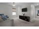 Cozy living room features a ceiling fan, TV, shelving, and comfortable seating at 4077 Cadence Loop, Land O Lakes, FL 34638