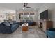 Open-concept living room with gray tile floors, neutral walls, ceiling fan, stylish sofas, and natural window shades at 4077 Cadence Loop, Land O Lakes, FL 34638
