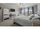 Comfortable bedroom with a mirrored closet, ceiling fan and plenty of natural light at 4077 Cadence Loop, Land O Lakes, FL 34638