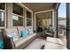 Cozy screened-in patio offers a comfortable seating area with cushioned furniture and stylish decor at 4077 Cadence Loop, Land O Lakes, FL 34638