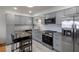 Updated kitchen with stainless steel appliances, subway tile backsplash, and modern gray cabinets at 416 73Rd N Ave # 205, St Petersburg, FL 33702
