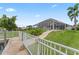 Backyard with a screened-in lanai, dock, lush landscaping, and waterfront access at 4306 Barracuda Dr, Bradenton, FL 34208