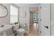 Bright half-bath with pedestal sink, stylish decor, and doorway to the home's main living areas at 4306 Barracuda Dr, Bradenton, FL 34208
