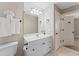 Bathroom with neutral walls and tile flooring features white cabinets, large mirror, and updated fixtures at 4306 Barracuda Dr, Bradenton, FL 34208