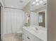 Bright bathroom with a white sink, cabinets, and a shower with a white shower curtain at 4306 Barracuda Dr, Bradenton, FL 34208