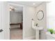 Bright half-bath with pedestal sink, stylish mirror, and view to adjacent living space at 4306 Barracuda Dr, Bradenton, FL 34208