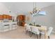 Bright dining area with neutral walls, elegant chandelier, and a wooden table complemented by modern white chairs at 4306 Barracuda Dr, Bradenton, FL 34208