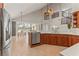 Modern kitchen featuring stainless steel appliances, custom wood cabinets, and open view to dining area at 4306 Barracuda Dr, Bradenton, FL 34208