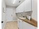 Functional laundry room with white cabinetry, a utility sink, and a door that leads to the outside at 4306 Barracuda Dr, Bradenton, FL 34208