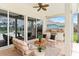 Outdoor patio featuring comfortable seating, ceiling fan, and a built-in outdoor kitchen area with a grill at 4306 Barracuda Dr, Bradenton, FL 34208
