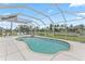 A pristine pool is surrounded by a large screened enclosure and a manicured yard with swaying palm trees at 4306 Barracuda Dr, Bradenton, FL 34208