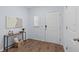 Bright entryway with wood floors, white door, console table with decor, and natural light at 4312 E Shadowlawn Ave, Tampa, FL 33610