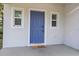 Close-up of a blue front door with white trim and a 'hello' welcome mat on the porch at 4312 E Shadowlawn Ave, Tampa, FL 33610