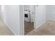 Hallway leading to a dedicated laundry room with modern appliances and plenty of space at 4312 E Shadowlawn Ave, Tampa, FL 33610