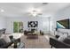 Inviting living area featuring wood floors, comfortable seating, and a large television at 4312 E Shadowlawn Ave, Tampa, FL 33610