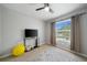 Bedroom featuring a window with view, a ceiling fan, a tv, grey walls and beige carpeting at 4504 Silver Lining St, Sarasota, FL 34238