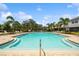 Beautiful community pool surrounded by palm trees and lounge chairs, offering a perfect oasis for relaxation and recreation at 4504 Silver Lining St, Sarasota, FL 34238
