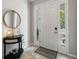 Bright entryway featuring tile flooring, a console table with mirror, and a welcoming front door with sidelights at 4504 Silver Lining St, Sarasota, FL 34238