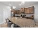 Spacious kitchen featuring granite countertops, stainless steel appliances, and a breakfast bar with pendant lighting at 4504 Silver Lining St, Sarasota, FL 34238