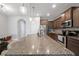 Open-concept kitchen with granite island, stainless steel appliances and a view into a connecting dining area at 4504 Silver Lining St, Sarasota, FL 34238