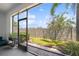 Screened lanai offering views of the backyard with lush landscaping and a privacy fence at 4504 Silver Lining St, Sarasota, FL 34238