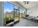 Relaxing screened lanai with plants, ceiling fan, and view of the yard with tropical foliage at 4504 Silver Lining St, Sarasota, FL 34238