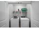 Small Laundry room with washer, dryer, white wire shelving, and a green laundry basket at 4504 Silver Lining St, Sarasota, FL 34238